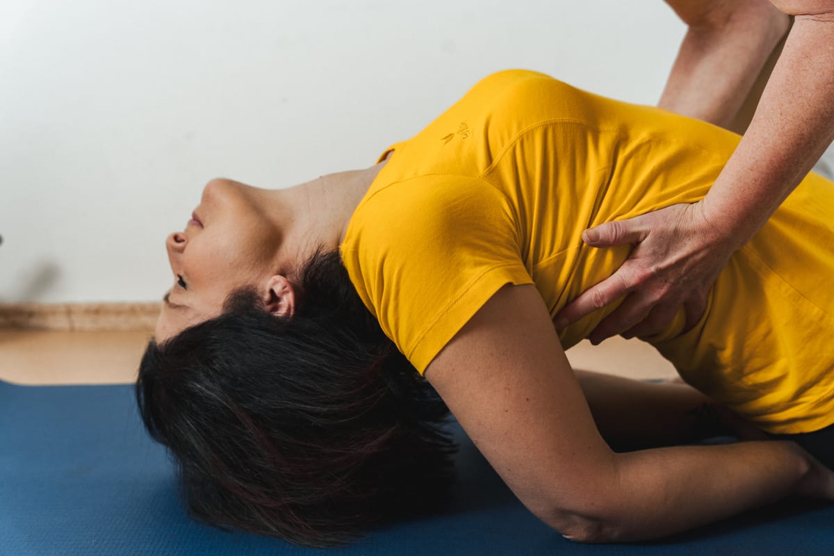 Kerstin Noack assistiert einer Teilnehmerin bei einer Yoga-Haltung