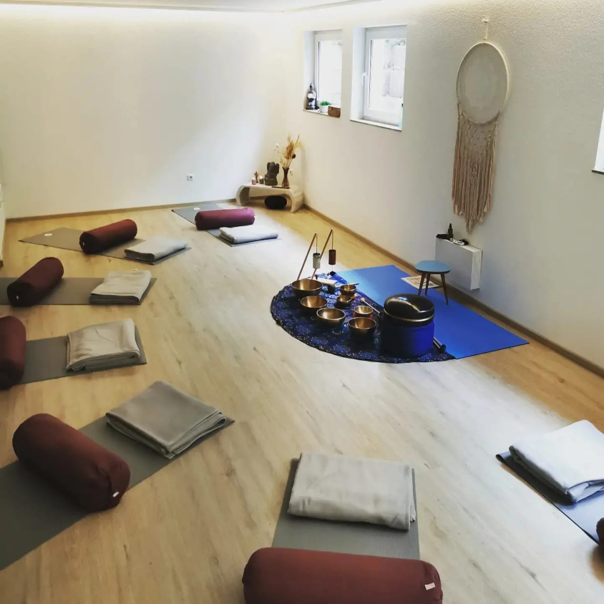 Kursraum mit Matten im Kreis und Klangschalen in der Mitte, vorbereitet für ein Klang-Ritual